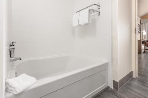a white bathroom with a tub and a sink at Holiday Inn & Suites Springfield-I-44 by IHG in Springfield