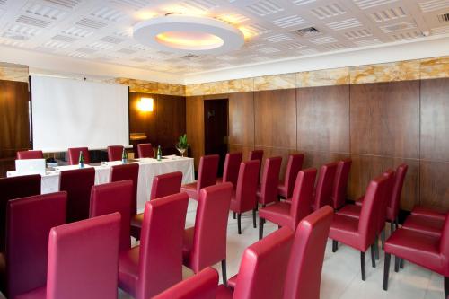 a conference room with red chairs and a whiteboard at Hotel Naples in Naples