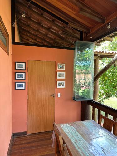 a dining room with a fish tank on the wall at Maresias Beach Cottage in São Sebastião