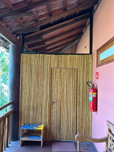 a wooden door in a room with a fire hydrant at Maresias Beach Cottage in São Sebastião