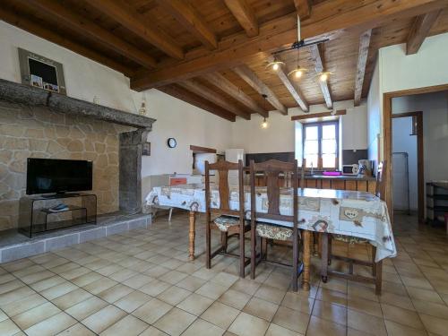 a living room with a table and a fireplace at Gîte en pierres avec cour et 3 chambres, au cœur d'un village proche de Langeac - FR-1-582-233 in Pinols