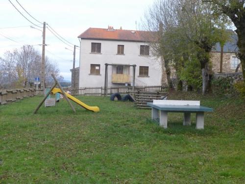 a playground with a slide and a table in a yard at Gîte en pierres avec cour et 3 chambres, au cœur d'un village proche de Langeac - FR-1-582-233 in Pinols