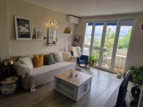 un salon avec un canapé et une table dans l'établissement Air conditioned, inviting and sunlit appartement- near Paris - free parking, à LʼHay-les-Roses