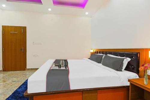 a bedroom with a large white bed with a wooden headboard at Collection O D N Grand in Rānchī