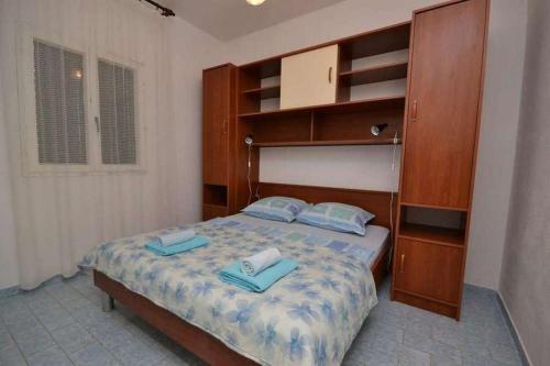 a bedroom with a bed with two pillows on it at Apartments with parking space Murvica, Brac - 23462 in Bol