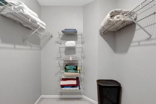 a walk in closet with white walls and white shelves at Stunning Heated Pool House for 10 in Brandon, FL in Brandon