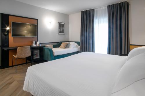 a hotel room with a bed and a couch at Hotel Cappello D'Oro, BW Signature Collection in Bergamo