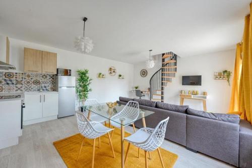 un salon avec un canapé, une table et des chaises dans l'établissement Lux Suite Don Giovanni, à Livry-Gargan