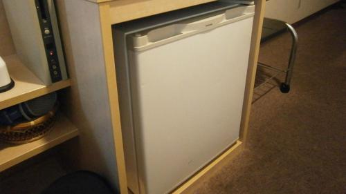 a small white refrigerator in a room with a counter at The Celecton Takamatsu in Takamatsu