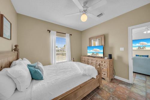 a bedroom with a bed and a window and a television at Dandy Sandy in Gulf Shores