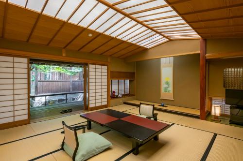 a room with a table and chairs and a window at Tokiwa Hotel in Kofu