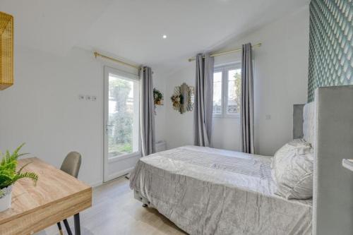 une chambre avec un lit, une table et des fenêtres dans l'établissement Lux Suite Lorenzo, à Livry-Gargan