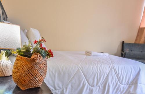 a vase of flowers sitting on a table next to a bed at Back Packer in Ibarra
