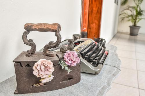a desk with a keyboard and a chair and flowers at Back Packer in Ibarra