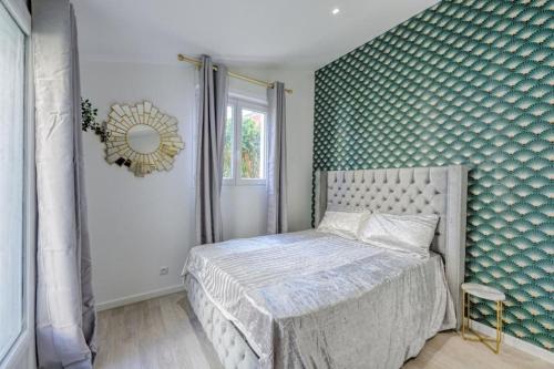 - une chambre dotée d'un lit avec un mur vert dans l'établissement Lux Suite Eliana, à Livry-Gargan