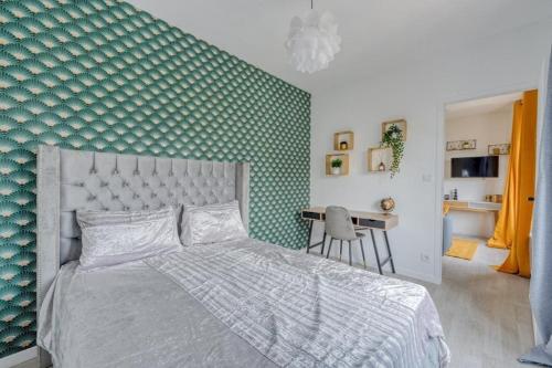 une chambre avec un lit et un mur végétal dans l'établissement Lux Suite Eliana, à Livry-Gargan