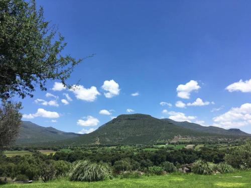 a view of a mountain from a field with trees at Hermosa Casa de Campo in El Varal