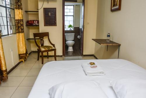 a bedroom with a bed and a bathroom with a toilet at Back Packer in Ibarra