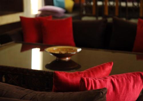 a table with red pillows and a bowl on top at Maison d'Hôtes à Marrakech in Marrakech