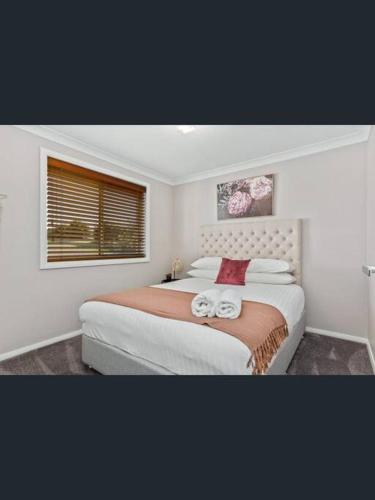 a bedroom with a large bed with two towels on it at Tranquility in Oberon