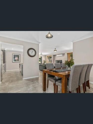 a dining room with a table and a clock on a wall at Tranquility in Oberon