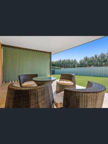 a patio with wicker chairs and a table with a view at Tranquility in Oberon
