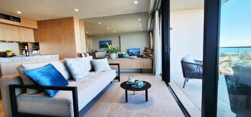 a living room with a couch and a table at Coastal Luxury overlooking Tamarama Beach in Sydney