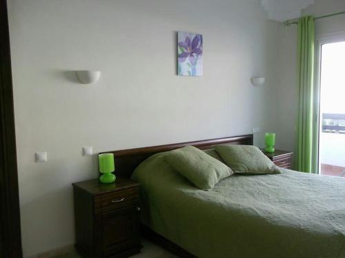 a bedroom with a bed with green candles on it at Luxurious Appart in Marina in Agadir