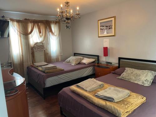 a bedroom with two beds and a chandelier at Self service small breakfast, 2 double beds private room in Montréal