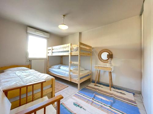 une chambre avec deux lits superposés et une fenêtre dans l'établissement Spacieux 3 pièces avec garage, climatisation, terrasse, proche centre à Sète - FR-1-338-584, à Sète