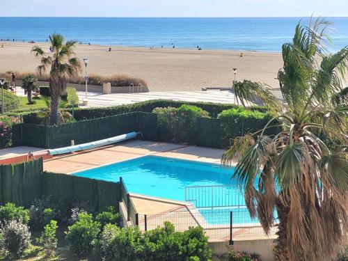 une piscine avec une plage en arrière-plan dans l'établissement Canet-en-Roussillon - T3 Moderne & Cosy - 6 pers - Clim, Garage - Piscine - FR-1-794-116, à Canet