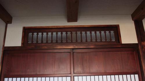 a wooden garage door with a railing above it at SOY in Takayama