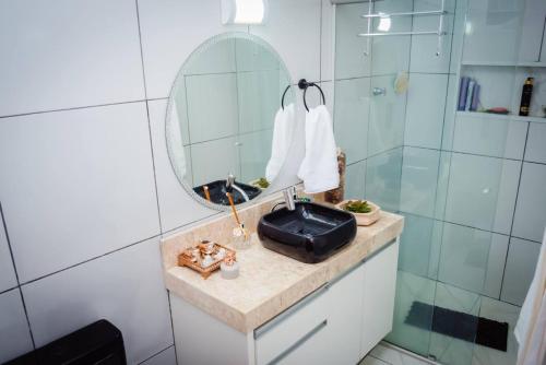 um banheiro com pia e espelho em Casa de Gente Feliz 2 em Cuiabá