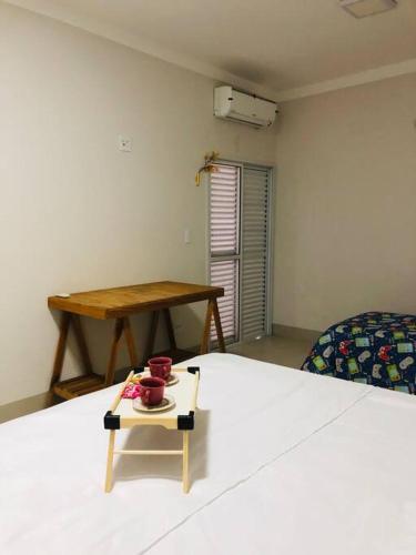 a room with a bed with a table and a tableasteryasteryasteryasteryastery at Casa próximo a Abda Hipica in Bauru