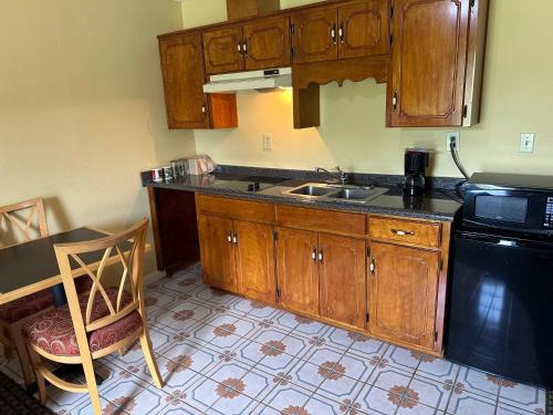 a kitchen with wooden cabinets and a sink and a stove at Royal Inn - Anniston in Anniston
