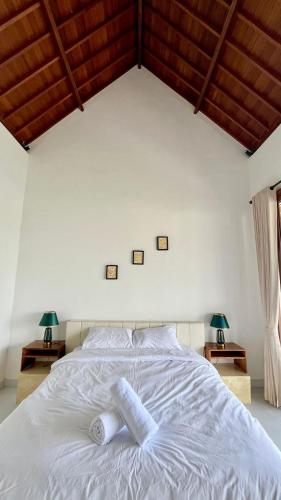 a white bed with two pillows on top of it at Sariuma babadan in Badung