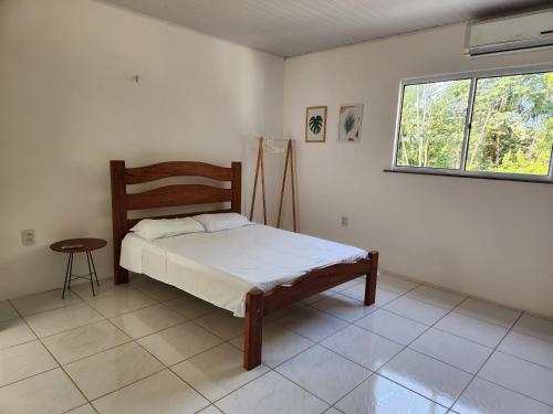 a bedroom with a bed and a window at Casa de Praia Araçagy in Macajatuba