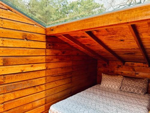 a bedroom in a wooden cabin with a bed in it at Casa Alfeñique in Villa del Carbón