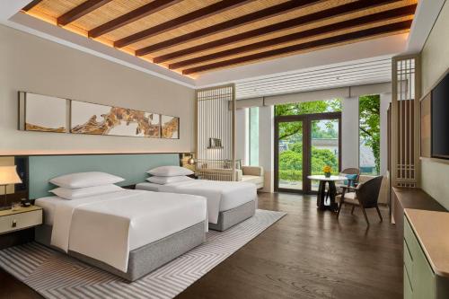 a bedroom with two beds and a living room at Park Hyatt Ningbo Resort & Spa in Ningbo
