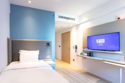 a hospital room with a bed and a flat screen tv at Holiday Inn Express Shanghai Pudong Airport by IHG in Shanghai