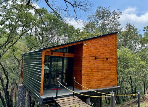 a tiny house on a trailer in the woods at Casa Alfeñique in Villa del Carbón