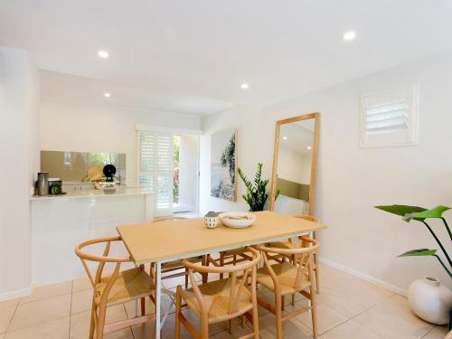 a dining room with a table and chairs at Noosa Parade Townhouse w/ Terrace by Stay Noosa in Noosa Heads
