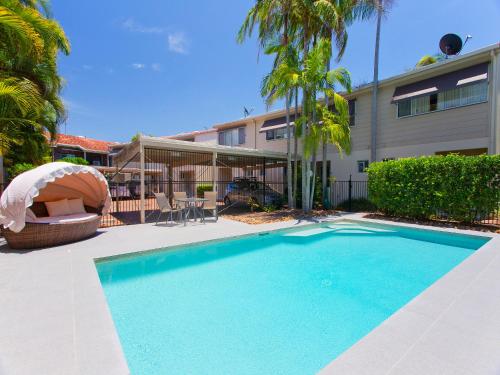 a swimming pool in front of a building at Noosa Parade Townhouse w/ Terrace by Stay Noosa in Noosa Heads