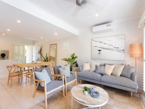 a living room with a couch and a table at Noosa Parade Townhouse w/ Terrace by Stay Noosa in Noosa Heads