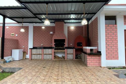 a patio with a brick building with a black ceiling at Villa Guerrero - Casa de Campo in Larán