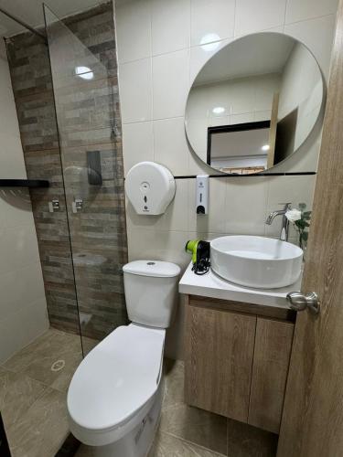 a bathroom with a toilet and a sink and a mirror at Hostelfc Usaquen in Bogotá