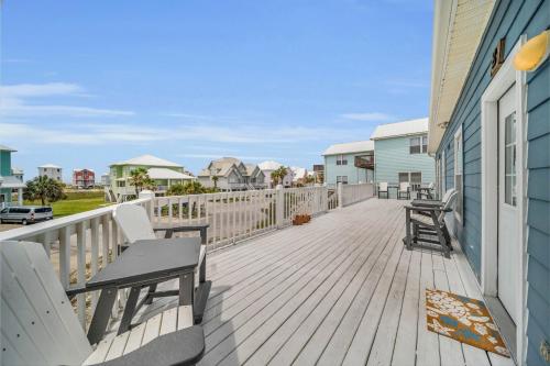 a wooden deck with chairs and tables on a house at Dandy Sandy in Gulf Shores