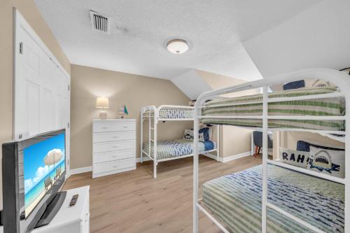 a bedroom with two bunk beds and a desk at Dandy Sandy in Gulf Shores