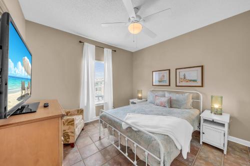 a bedroom with a bed and a flat screen tv at Dandy Sandy in Gulf Shores