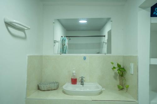 a bathroom with a sink and a mirror at Posada Stoy Places in Providencia